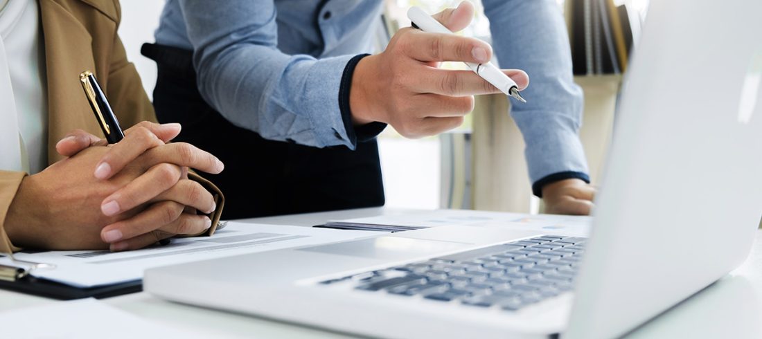 Two business people analysing a finance transaction on a computer screen